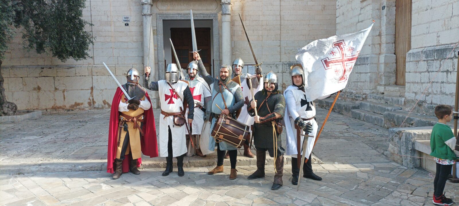 Els recreadors alcen espases davant una església d'Inca, amb tambor i estendard de creu templera.